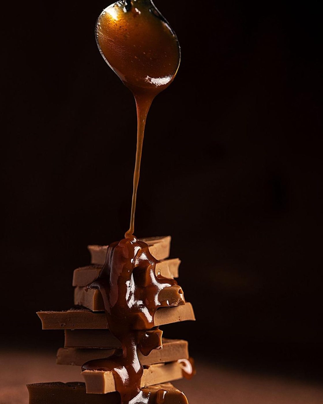 Caramel au beurre salé coulant à la cuillère sur des morceaux de caramel tendre